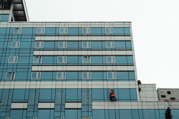 Arbeitende Reinigung der Fenster des Hochhauses, draußen. Industriekletterer