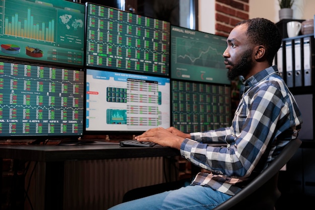 Arbeitender Geschäftsmann, der Forex-Börsenereignisse verfolgt, um den nächsten Kursrückgang vorherzusagen. Makleragent, der Finanzdatendiagramme in Echtzeit analysiert, während er eine Workstation mit mehreren Monitoren verwendet.