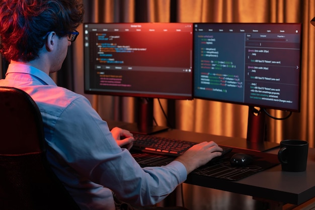 Arbeitender IT-Entwickler konzentriert sich auf Online-Software im Neonlichtraum Gusher