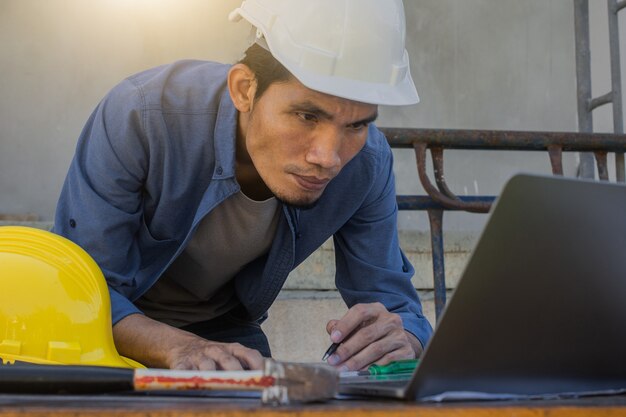 Arbeiter Angestellter, der mit Computertechnologie auf der Baustelle arbeitet