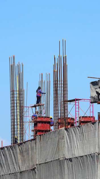 Arbeiter auf Hochbau-Baustelle und Stahl- und Betonmaterial.