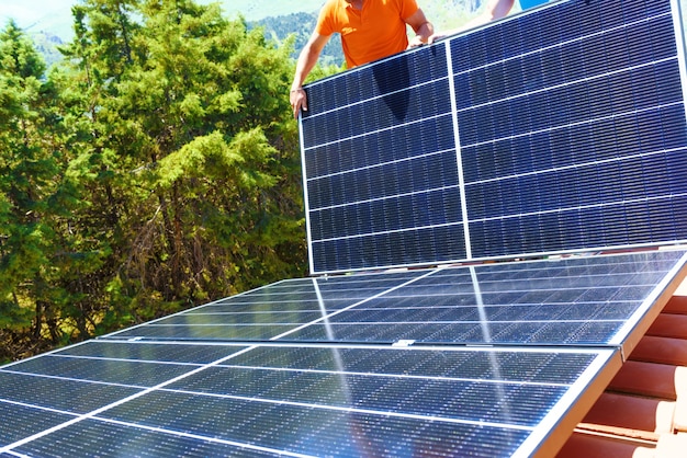 Arbeiter bauen Energiesystem mit Sonnenkollektor für Strom und Warmwasser zusammen