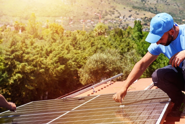 Arbeiter bauen Energiesystem mit Sonnenkollektor für Strom zusammen