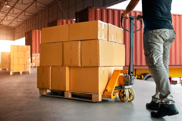 Arbeiter beim Entladen von Verpackungsboxen auf Paletten in der Warenversorgungskette der Lagerlieferungs-Versandboxen