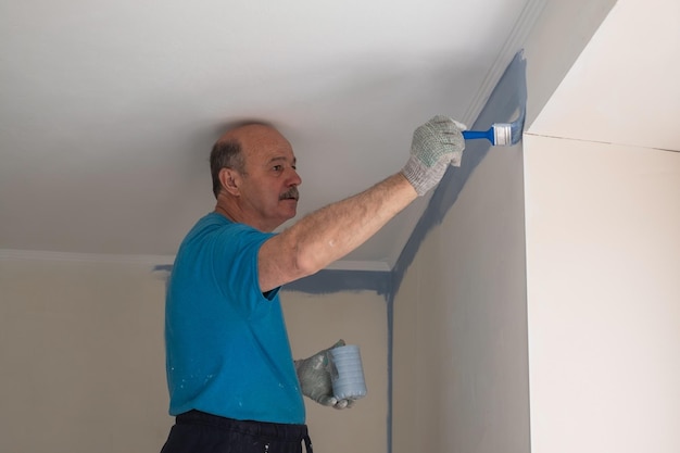 Arbeiter beim Streichen von Wänden mit einem Pinsel während der Wohnungsrenovierung
