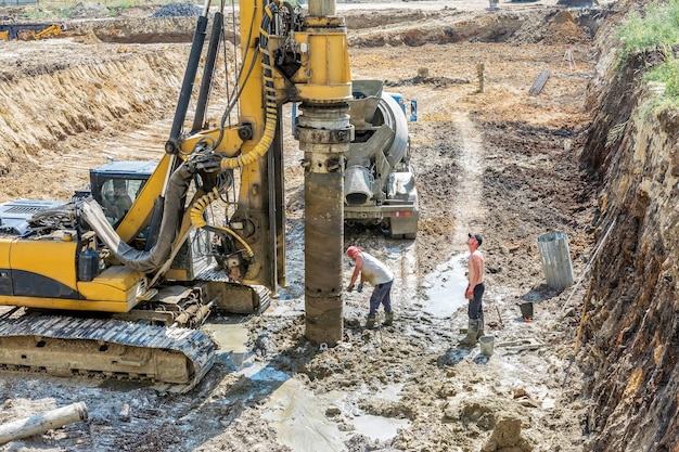 Arbeiter bohren einen Brunnen für den Bau des Fundaments eines Industriegebäudes