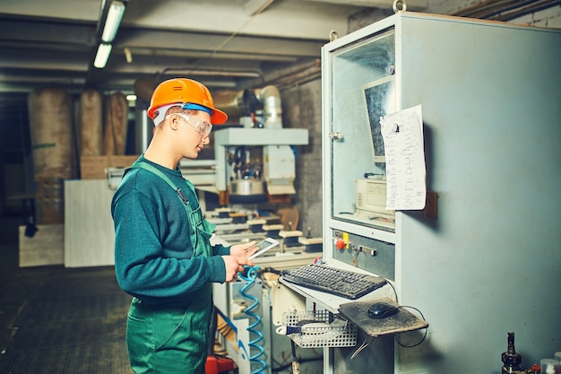 Arbeiter, der computergesteuerte Maschinen in der Fabrik bedient