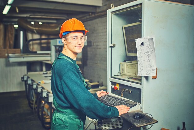 Arbeiter, der computergesteuerte Maschinen in der Fabrik bedient