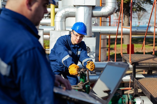 Foto arbeiter, der das messgerät in der ölraffinerie anpasst