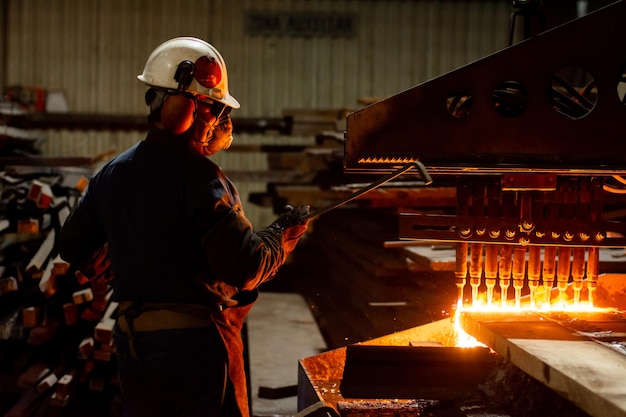 Arbeiter, der eine CNC-Autogen-Schneidemaschine in einer Fabrik überprüft