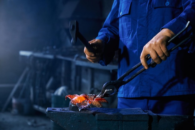 Arbeiter, der Hammer hält und Metall herstellt