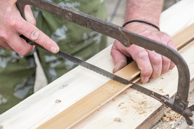 Arbeiter, der Holz mit Säge schneidet.