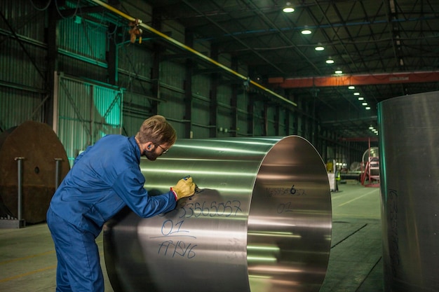 Arbeiter, der Metall in der Fabrik kennzeichnet