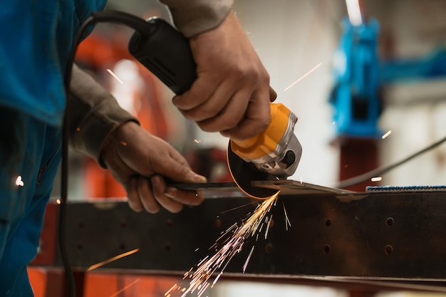 Foto arbeiter, der mit einem kreisschleifer an einem metall mit funken arbeitet