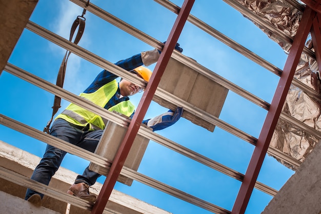 Arbeiter, die Dächer in Sicherheitskleidung installieren Bau einer Hausdach-, Keramik- oder CPAC-Dachziegelindustrie