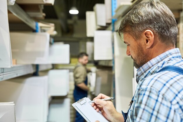 Foto arbeiter, die inventar im lager machen