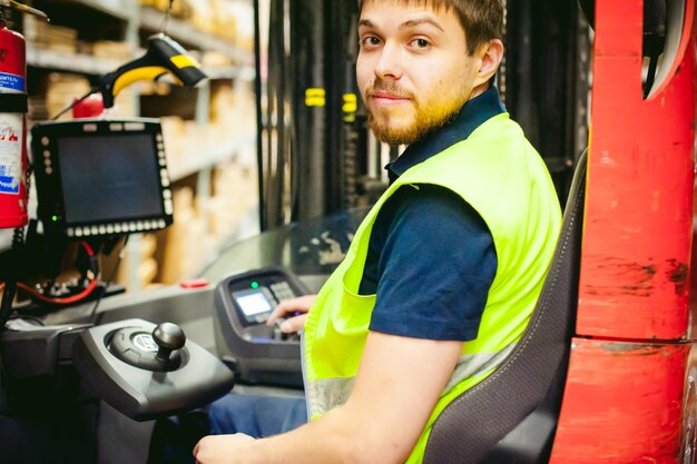 Foto arbeiter fährt einen gabelstapler in einer fabrik