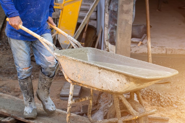 Arbeiter gießen Beton auf der BaustelleStahlstangen für Bodenbauarbeiten Arbeiter gießen für den Bau eines WohngebäudesxA