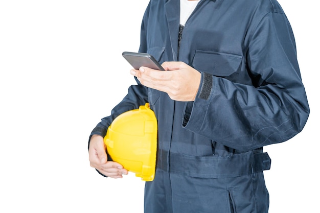Arbeiter im blauen Overall mit Helm und Smartphone