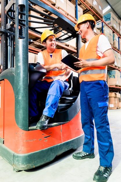 Arbeiter im Logistiklager an der Gabelstapler-Checkliste