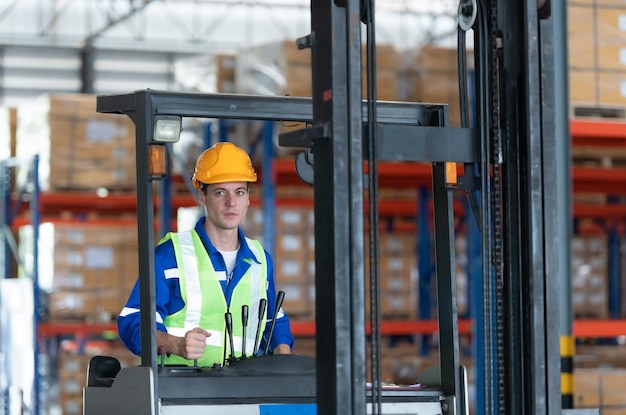 Arbeiter in einem Auto-Teilspeicher benutzen einen Gabelstapler zur Arbeit, um die Kiste mit Autoteilen zu bringen