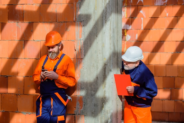 Arbeiter in Helm zwei Mechaniker auf Bauwerbung Mechaniker Hammer Schraubenschlüssel