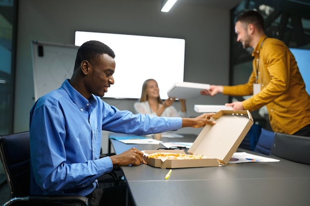 Arbeiter isst Pizza, Geschäftsessen im IT-Büro