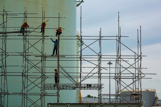 Arbeiter männliche Montage im Gange Lagerung neuer Tank Ölinspektionsgerüst