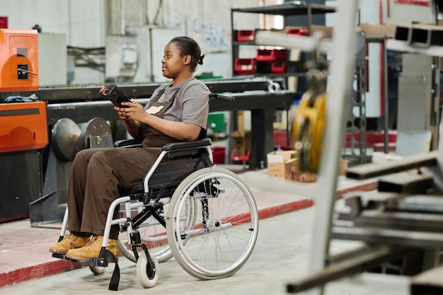Arbeiter mit Behinderung, der an der Maschine arbeitet