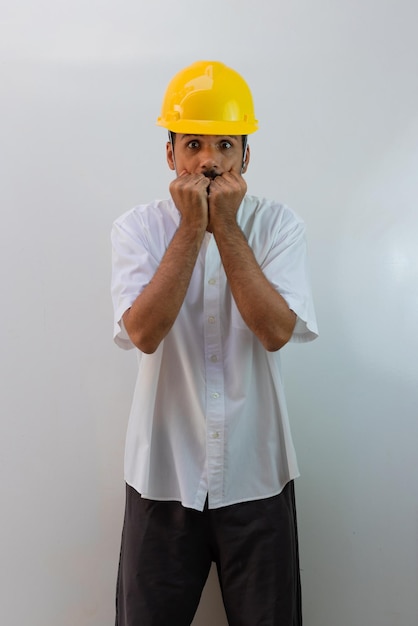 Arbeiter mit Helm auf weißem Hintergrund. Schwarzer Mann in einem Helm mit überraschenden Ausdrücken.