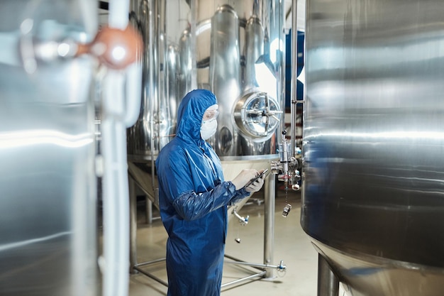 Arbeiter mit Schutzanzug in der Werkstatt der industriellen Chemiefabrik