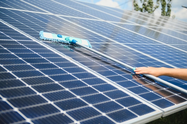 Arbeiter reinigen Solarmodule nach der Installation im Freien