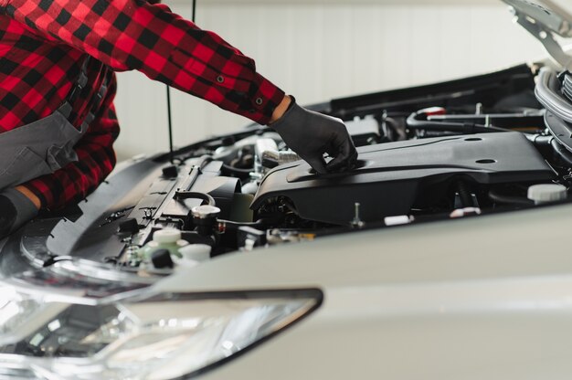 Arbeiter repariert ein Auto in einem Autoreparaturzentrum