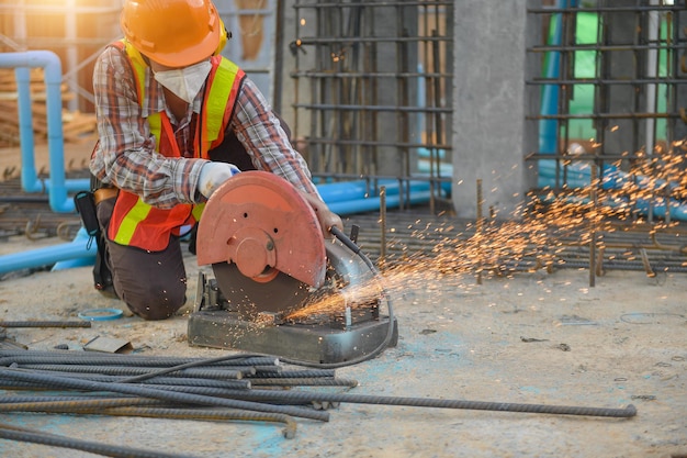 Arbeiter schneiden Stahl mit Kreisscheibe der Schneidemaschine schneidet einen Teil des Eisens ab, bis beim Schneiden von Stahl Funken entstehen.