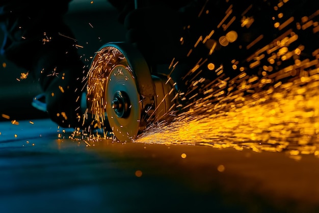 Arbeiter schneidet ein Stahlblech mit einer Schleifmaschine mit einer Scheibe Helle Funken vom Metallschneiden Nahaufnahme Vorderansicht