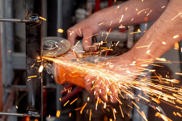 Arbeiter schneidet Metall mit Winkelschleifer