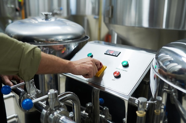 Arbeiter startet Brauereiausrüstung