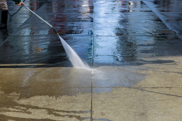 Foto arbeiter wäscht den asphalt in der fußgängerzone in der modernen großstadt