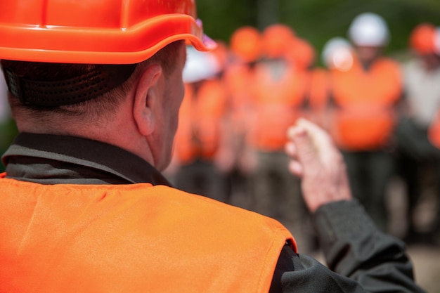 Arbeitergruppe mit Sicherheitsweste Gebäudekonzept Architekt Ingenieure auf der Baustelle Baumeister Mann Helmbauer Viele Bauarbeiter Helm Ingenieurteam in Hardhat für die Arbeit