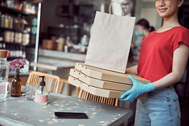 Arbeiterin, die Kisten mit Lebensmitteln im Haus trägt