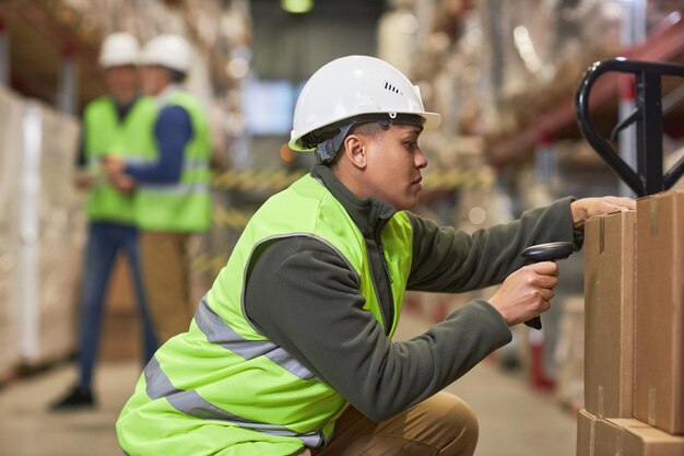 Foto arbeiterinnen scannen codes auf kartons im lagerhaus