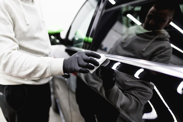 Arbeiterreinigungsauto - Konzept der Autodetaillierung (oder des Aufräumens). Selektiver Fokus.