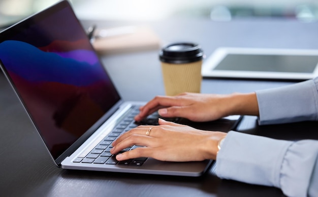 Arbeitet an ihrem neuesten Projekt Schnappschuss einer nicht wiederzuerkennenden Geschäftsfrau, die im Büro an ihrem Laptop arbeitet