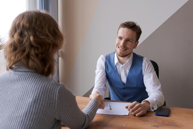 Arbeitgeber schüttelt Hände und lächelt qualifiziertem unternehmerischem Bewerber um eine Stelle zu