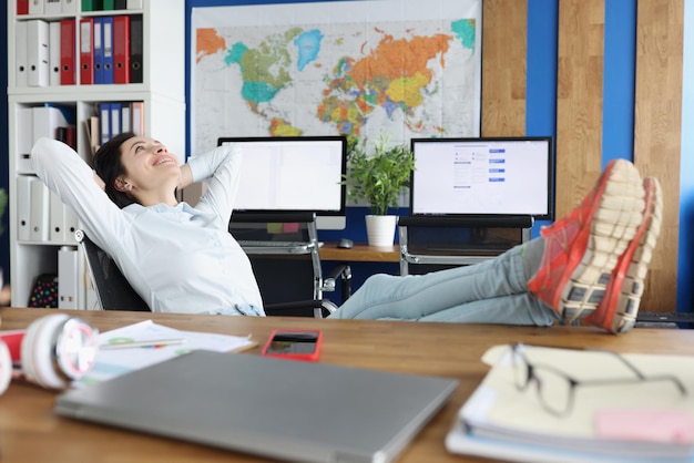 Arbeitnehmerin chillt und legt nach einem harten Arbeitstag Beine auf den Tisch