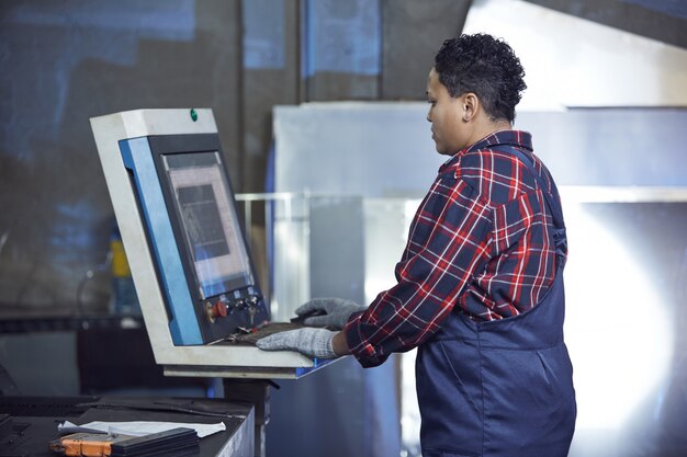 Foto arbeitnehmerin mit maschinen in der fabrik