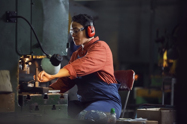 Arbeitnehmerin mit Maschinen in der Fabrik