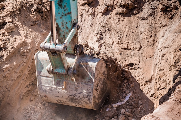 Arbeitsbagger-Traktor, der einen Graben graben.