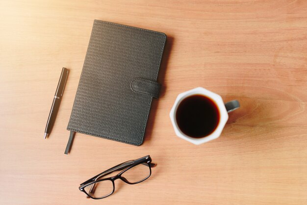 Arbeitsgeräte auf dem Holztisch mit einer Tasse Kaffee