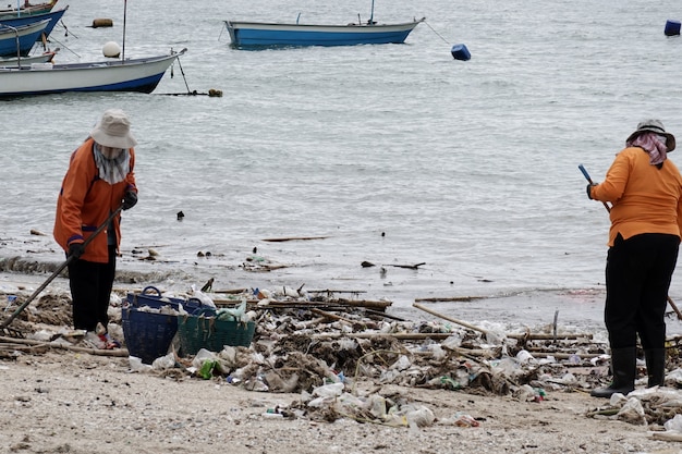 Arbeitskräfte, die Strand vom Abfall säubern.